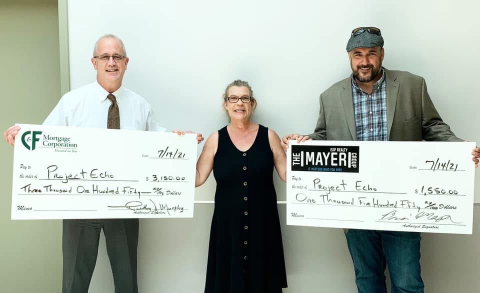 Brian Mayer presenting a donation check to Project Echo